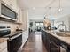 Modern kitchen featuring stainless steel appliances, dark wood floors, and a large island at 2017 New Hope Branch Way, Belmont, NC 28012