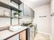 Well-organized laundry room with modern washer/dryer, cabinets, open shelving, and tiled flooring at 2017 New Hope Branch Way, Belmont, NC 28012