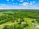 Aerial view of land surrounded by mature trees with road frontage and nearby homes and farmland at 2309 Potter S Rd, Waxhaw, NC 28173