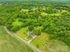 Aerial view of a house on a large lot with mature trees and adjacent farmland at 2309 Potter S Rd, Waxhaw, NC 28173