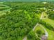 Aerial view of land surrounded by mature trees with road frontage and nearby houses at 2309 Potter S Rd, Waxhaw, NC 28173