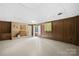 Unfinished basement featuring paneled walls, tiled floors, and a brick fireplace with adjacent cabinets and large, bright space at 2309 Potter S Rd, Waxhaw, NC 28173