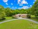 Gravel driveway leading to a house with a combination brick and stone facade at 2309 Potter S Rd, Waxhaw, NC 28173