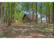 Cozy cabin-style home nestled among trees, with a glimpse of the lake in the background at 2563 Brawley School Rd, Mooresville, NC 28117