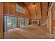 Large living room features a fireplace, wood ceiling and floors, with lake view through sliding glass doors at 2563 Brawley School Rd, Mooresville, NC 28117