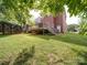 Exterior view of a red brick home with a wooden deck and a lush green lawn at 2608 Golden Bell Dr, Gastonia, NC 28056