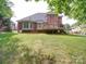 Exterior view of a red brick home with a wooden deck surrounded by greenery at 2608 Golden Bell Dr, Gastonia, NC 28056