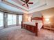 Comfortable main bedroom featuring a tray ceiling, a ceiling fan, and large windows at 2608 Golden Bell Dr, Gastonia, NC 28056