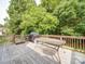 Wooden deck with a grill and a dining table surrounded by lush greenery at 2608 Golden Bell Dr, Gastonia, NC 28056