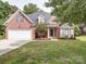 Charming brick home featuring a manicured lawn, attached garage, and attractive landscaping at 2608 Golden Bell Dr, Gastonia, NC 28056