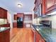 Spacious kitchen showcasing dark countertops, wood cabinetry, stainless steel appliances, and hardwood floors at 2608 Golden Bell Dr, Gastonia, NC 28056