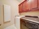 Modern laundry room with dark wood cabinets and stainless steel dryer at 2608 Golden Bell Dr, Gastonia, NC 28056