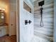 Modern walk-in shower with a rainfall showerhead, handheld sprayer, and stone tile at 2608 Golden Bell Dr, Gastonia, NC 28056