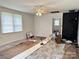 Bright living room featuring a ceiling fan and a brick fireplace, with floors partially updated and windows at 2791 Neill Rd, Lancaster, SC 29720