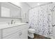 Bathroom with white vanity, framed mirror, and blue floral shower curtain at 2996 N Lookout St, Claremont, NC 28610