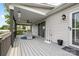 Covered porch features gray decking, wicker furniture, a ceiling fan, and access to the backyard at 2996 N Lookout St, Claremont, NC 28610