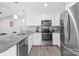 The kitchen features stainless appliances, a tiled backsplash, and lots of lighting at 2996 N Lookout St, Claremont, NC 28610