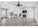 Open-concept living room showcases a fireplace, ceiling fan, and kitchen bar at 2996 N Lookout St, Claremont, NC 28610