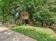 Spacious backyard featuring a custom treehouse, wooden deck, and lush landscaping at 3459 Selwyn Ave, Charlotte, NC 28209
