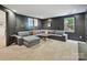 Spacious basement with L-shaped sofa, a window, neutral carpet, and dark walls at 3459 Selwyn Ave, Charlotte, NC 28209