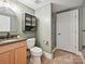 Modern bathroom with wooden vanity, toilet, and glass-enclosed shower at 3459 Selwyn Ave, Charlotte, NC 28209