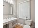 Well-lit bathroom with pedestal sink, toilet, decorative mirror, and neutral paint at 3459 Selwyn Ave, Charlotte, NC 28209