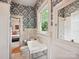 Elegant bathroom featuring floral wallpaper, white fixtures, and a window with natural light at 3459 Selwyn Ave, Charlotte, NC 28209