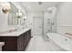 Elegant bathroom featuring dual vanities, a glass-enclosed shower, and a soaking tub at 3459 Selwyn Ave, Charlotte, NC 28209