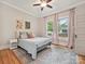 Bedroom with hardwood floors, area rug, and two windows with nice curtains at 3459 Selwyn Ave, Charlotte, NC 28209