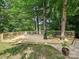 Outdoor wooden deck furnished with chairs and table, surrounded by trees and greenery at 3459 Selwyn Ave, Charlotte, NC 28209