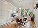 Bright dining area with hardwood floors, built-in cabinets, and a round table at 3459 Selwyn Ave, Charlotte, NC 28209