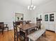 Bright dining room with hardwood floors, a farmhouse table, and modern light fixture at 3459 Selwyn Ave, Charlotte, NC 28209