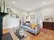 Bright living room with a fireplace, hardwood floors, and gray sofa at 3459 Selwyn Ave, Charlotte, NC 28209