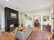 Bright living room with hardwood floors, a black fireplace, and an open doorway to the dining room at 3459 Selwyn Ave, Charlotte, NC 28209