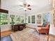 Light-filled sunroom with large windows, desk, ceiling fan, and cozy chair at 3459 Selwyn Ave, Charlotte, NC 28209
