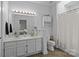 Well-lit bathroom with double sinks, white cabinets, and a separate toilet area at 3801 Rosedown Dr, Matthews, NC 28105