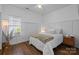Comfortable bedroom with neutral colors, paneling, and hardwood flooring at 3801 Rosedown Dr, Matthews, NC 28105