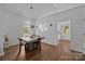 Bright dining room with modern light fixture, hardwood floors, and view of the kitchen at 3801 Rosedown Dr, Matthews, NC 28105