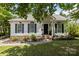 Charming single-story home with a well-manicured lawn, black shutters and arched windows at 3801 Rosedown Dr, Matthews, NC 28105