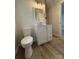 Bright bathroom featuring a white toilet and vanity with wood-look flooring at 408 N Hill St, Dallas, NC 28034