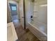 Clean bathroom showcasing a white bathtub, wood-look flooring, and modern fixtures at 408 N Hill St, Dallas, NC 28034