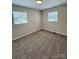Bedroom featuring neutral carpet and two windows with natural light at 408 N Hill St, Dallas, NC 28034
