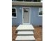 Charming front entrance with gray door and matching concrete steps on a home with attractive blue siding at 408 N Hill St, Dallas, NC 28034
