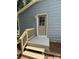 Attractive front door with decorative window, sturdy-looking wooden banister, and complementary gray concrete steps at 408 N Hill St, Dallas, NC 28034