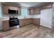 Well-lit kitchen with modern appliances, light wood flooring and ample counter space at 408 N Hill St, Dallas, NC 28034