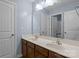 Bathroom with double sinks, wood cabinets, and a large mirror reflecting the bathroom at 4117 Bright Rd, Charlotte, NC 28214