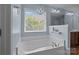 Bathroom featuring a soaking tub next to a window with an elegant chandelier at 4117 Bright Rd, Charlotte, NC 28214