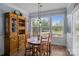 Bright breakfast nook featuring a wooden table set, tiled floor, and a large window overlooking the backyard at 4117 Bright Rd, Charlotte, NC 28214