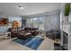 Comfortable living room featuring blue rug, leather sectional, fireplace, and natural light at 4117 Bright Rd, Charlotte, NC 28214
