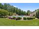 Beautiful community pool featuring lounge chairs, umbrellas, and mature trees around the perimeter on a sunny day at 4117 Bright Rd, Charlotte, NC 28214